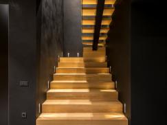 Treppe aus Holz mit schwarzen Wänden