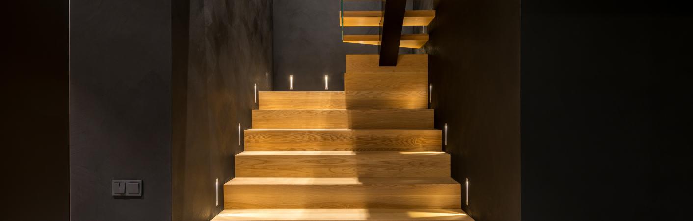 Treppe aus Holz mit schwarzen Wänden